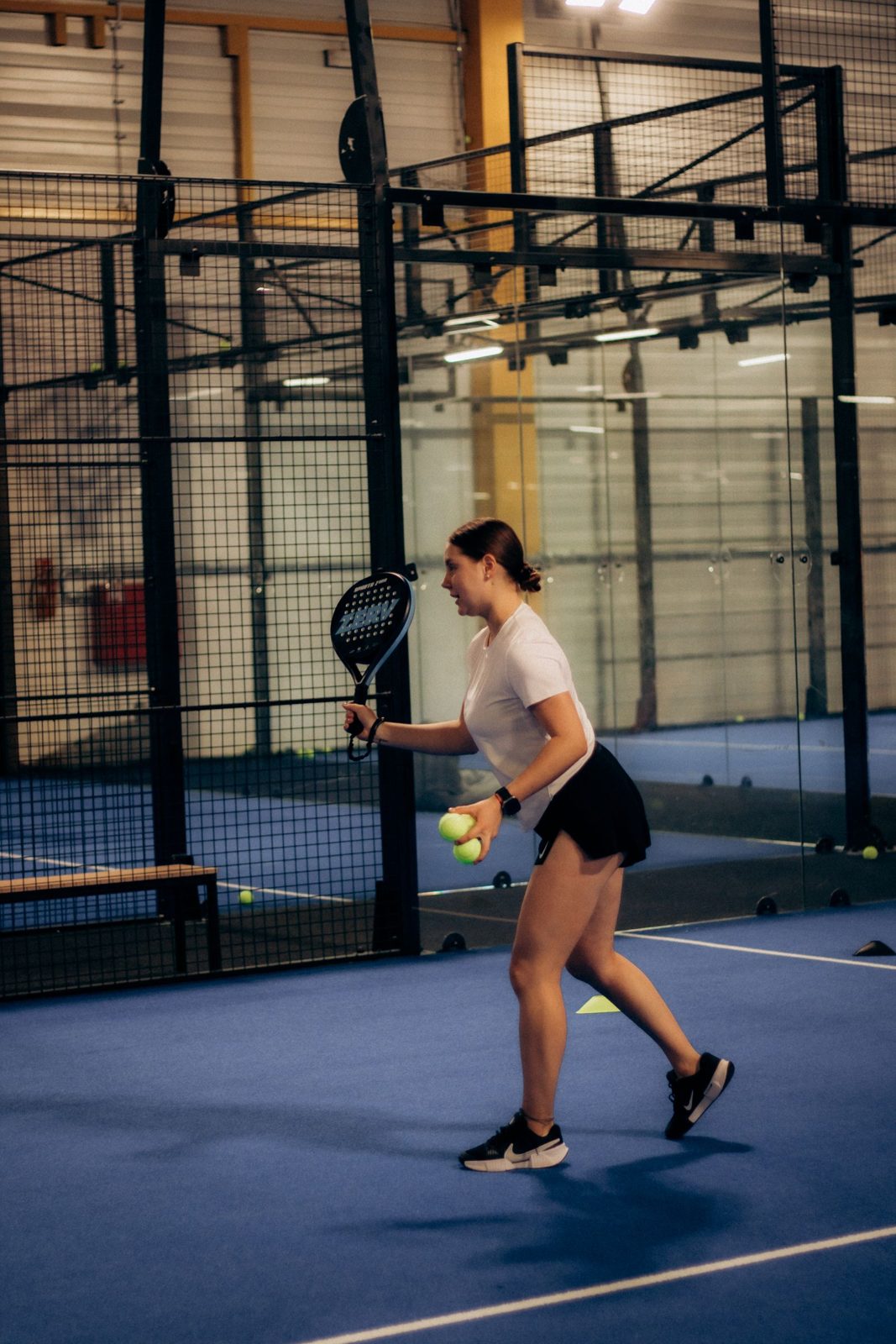 Player preparing to hit the ball on an indoor padel court