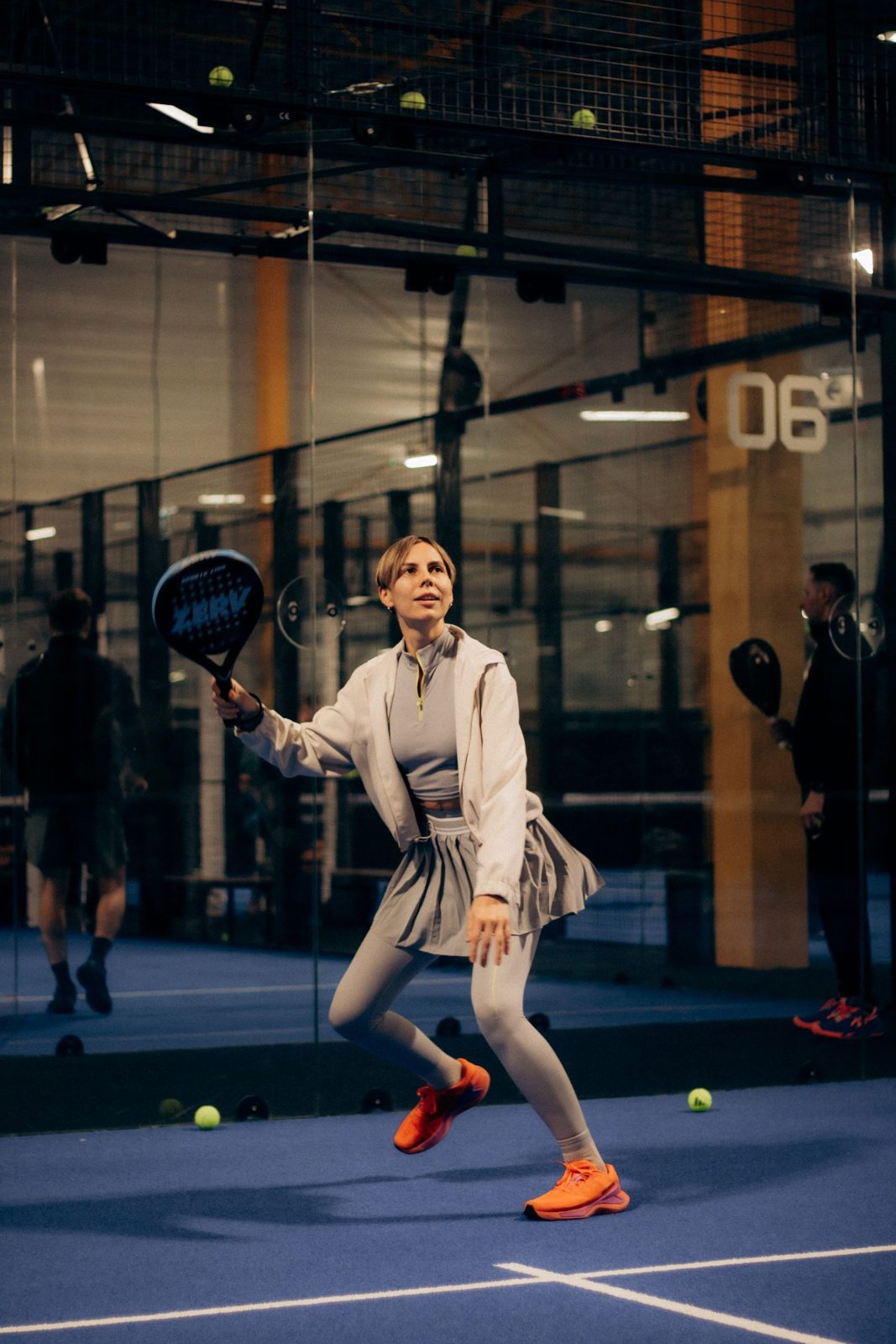 Player hitting a shot during an indoor padel rally